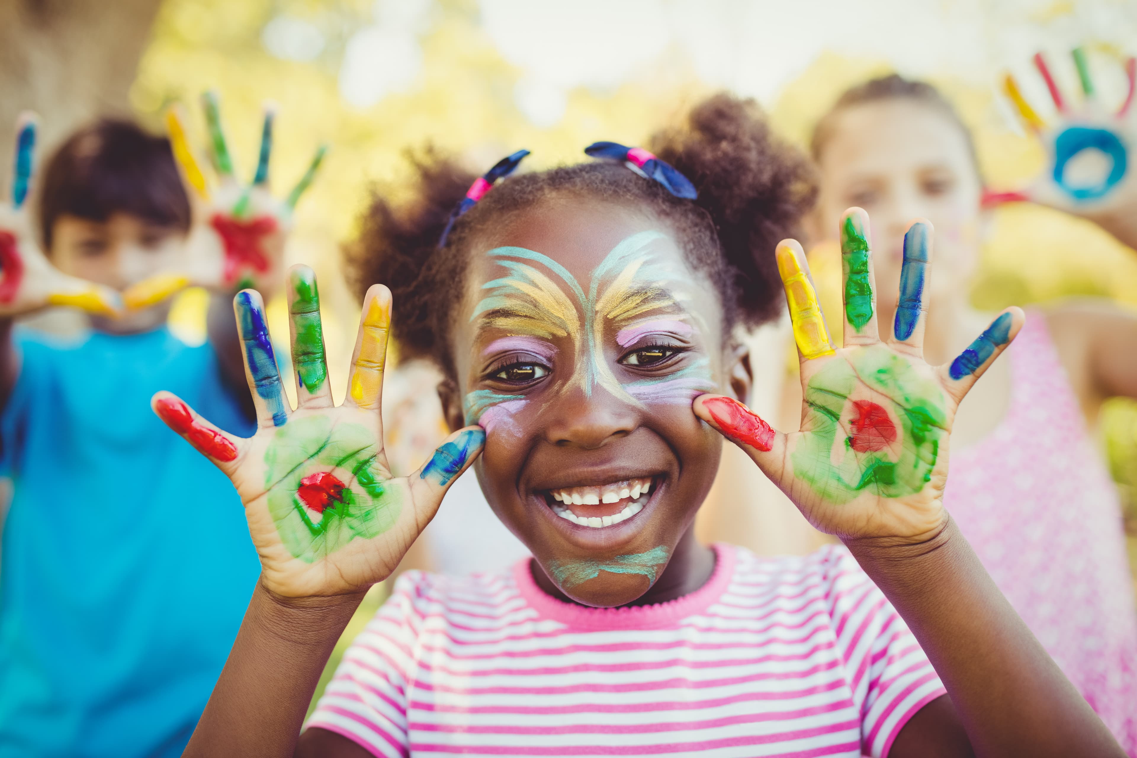 Portrait of a girl with make-up showing her painted hands in a park portrait-girl-with-make-up-showing-her-painted-hands