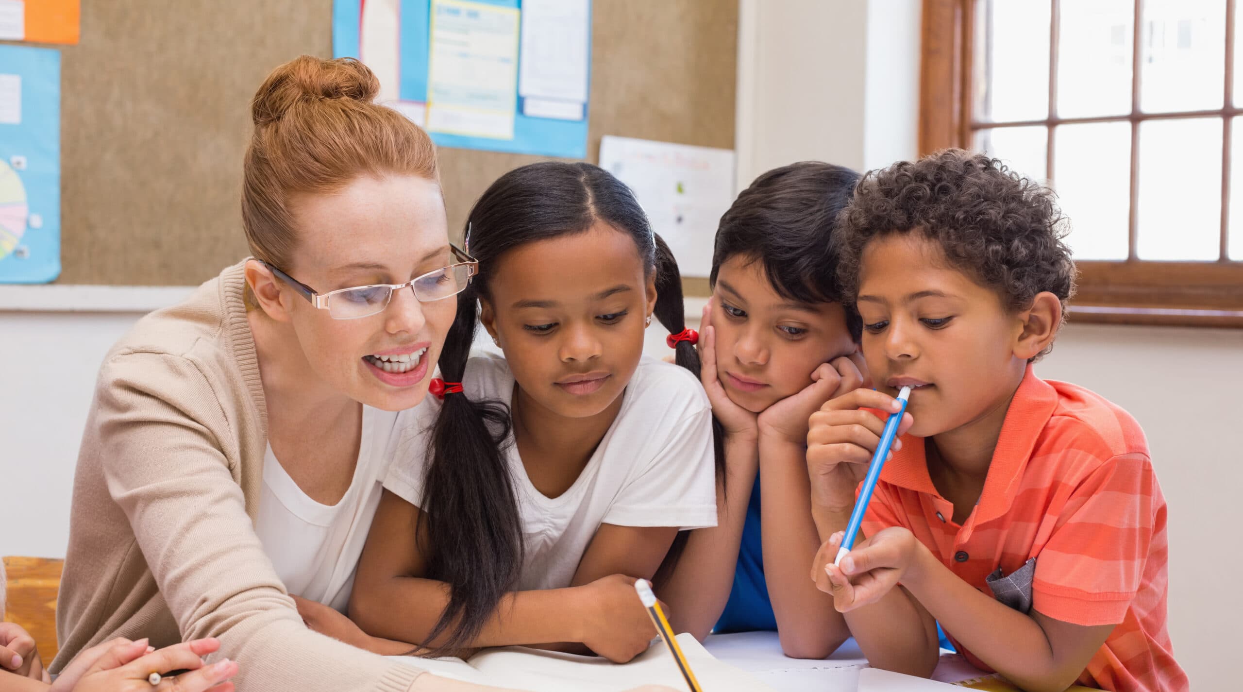teacher-pupils-working-desk-together